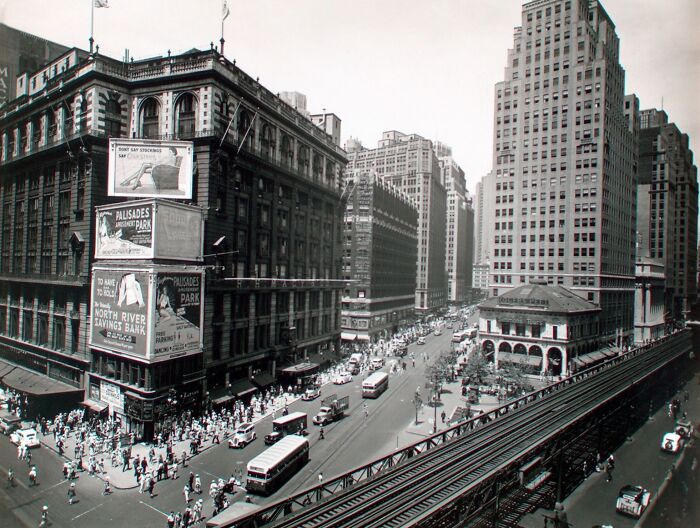 Busy city street and elevated train tracks captured in a rare photo from the Great Depression era showing urban life and transportation.
