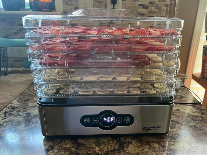 Electric food dehydrator with trays of sliced fruits drying, a popular infomercial find for home use.