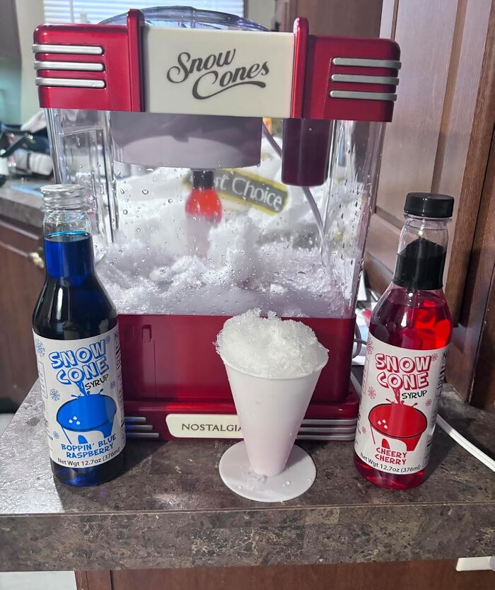 Retro snow cone machine with blue raspberry and cherry syrups, serving a classic shaved ice treat for old soul nostalgia.