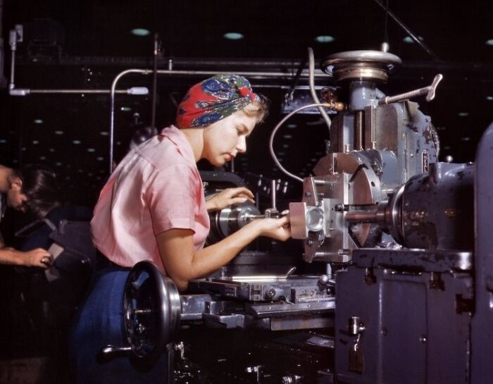 Woman operating industrial machinery, showcasing the bold, brilliant world of women at work during WWII.