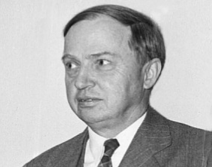 Black and white portrait of a man in a suit illustrating unusual and cool world facts for interesting conversations.