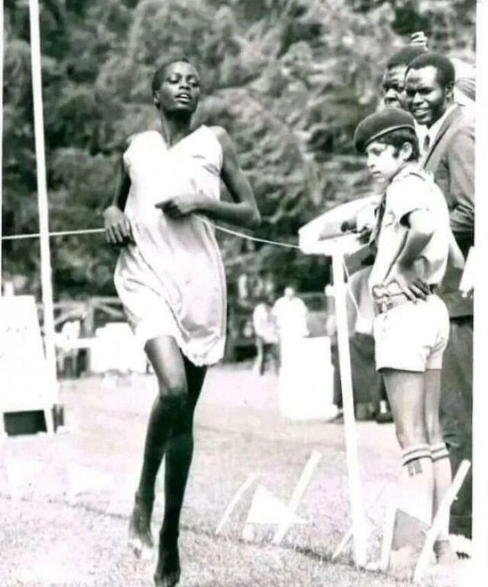 Black and white photo of a barefoot runner crossing the finish line, illustrating unusual and cool world facts.