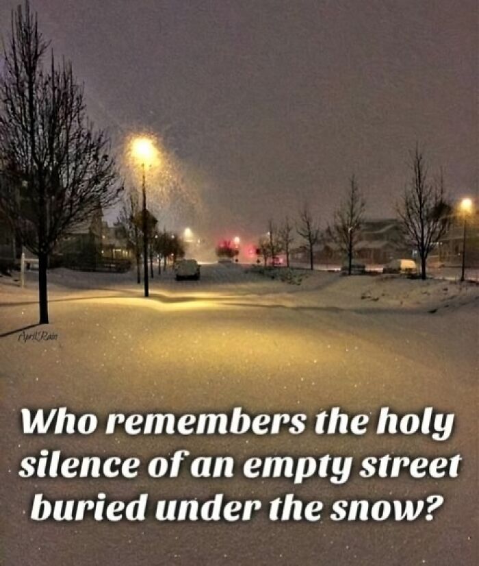 Snow-covered empty street at night with glowing streetlights capturing the peaceful silence from the good old days of the 80s.