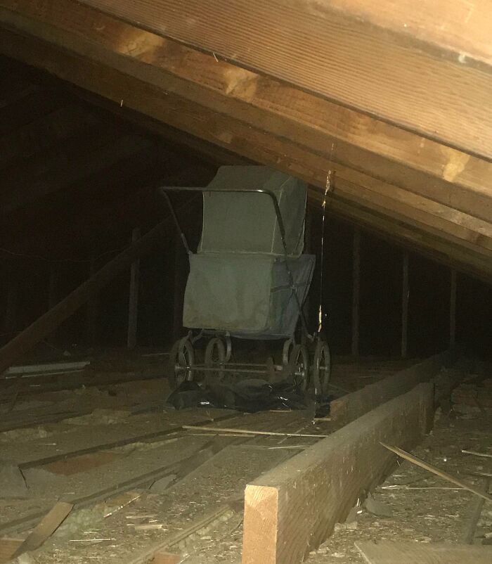 Old baby carriage stored under attic floor boards, a surprising fossil-like find in an old home discovery.