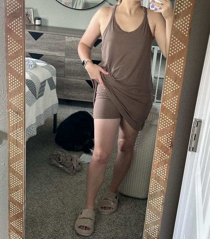 Woman trying on comfortable best sellers clothing in front of bedroom mirror during Prime Day fashion haul.