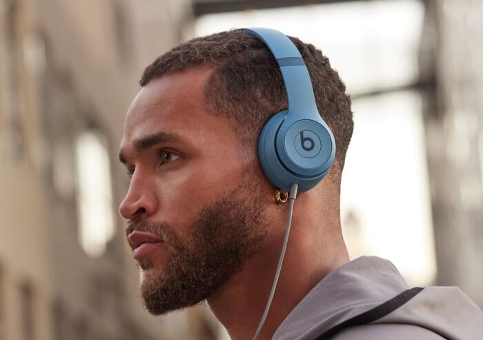 Man wearing blue Beats headphones outdoors, representing best sellers that topped the charts on Prime Day.