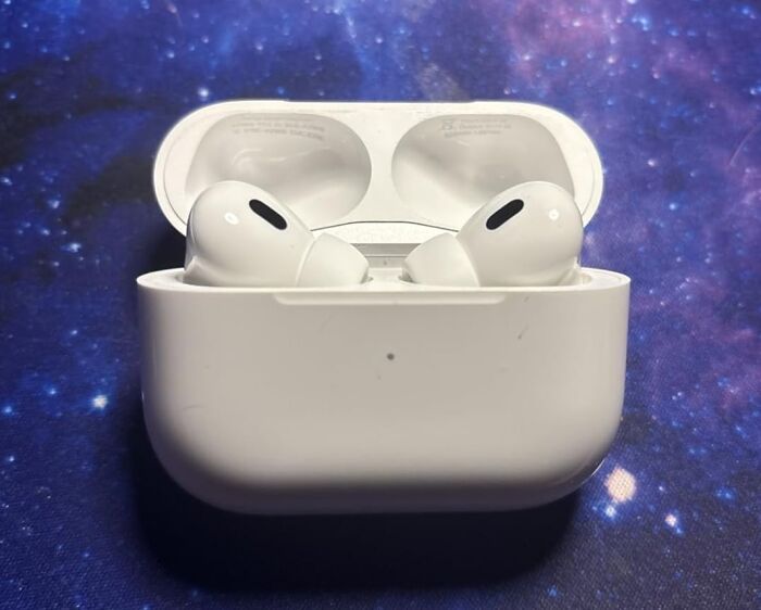 White wireless earbuds in open charging case on a galaxy-patterned surface, popular best sellers topping Prime Day charts.
