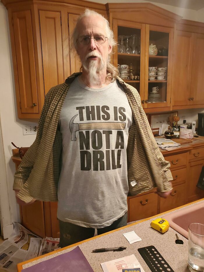Older dad wearing a clever hammer-themed shirt showing his hilarious side, perfect for dads nailing fatherhood.