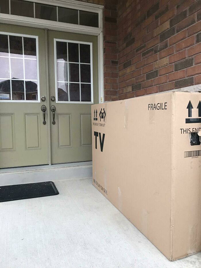 Large fragile TV package delivered at front doorstep of a home, highlighting deliveries gone off track and package fell into ocean risks.