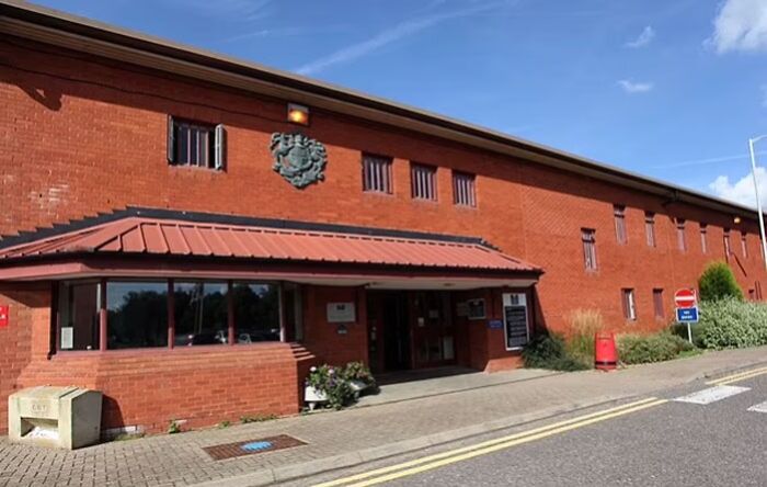 Exterior view of a red brick building under blue sky, symbolizing consequences of stupidity and lost jobs cases.