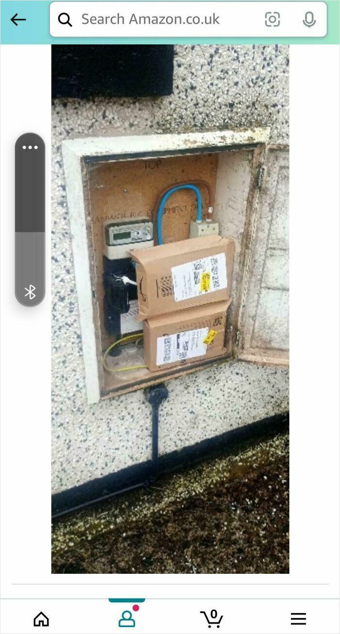 Packages awkwardly placed inside an outdoor electrical box, showing unusual and off track delivery placement.