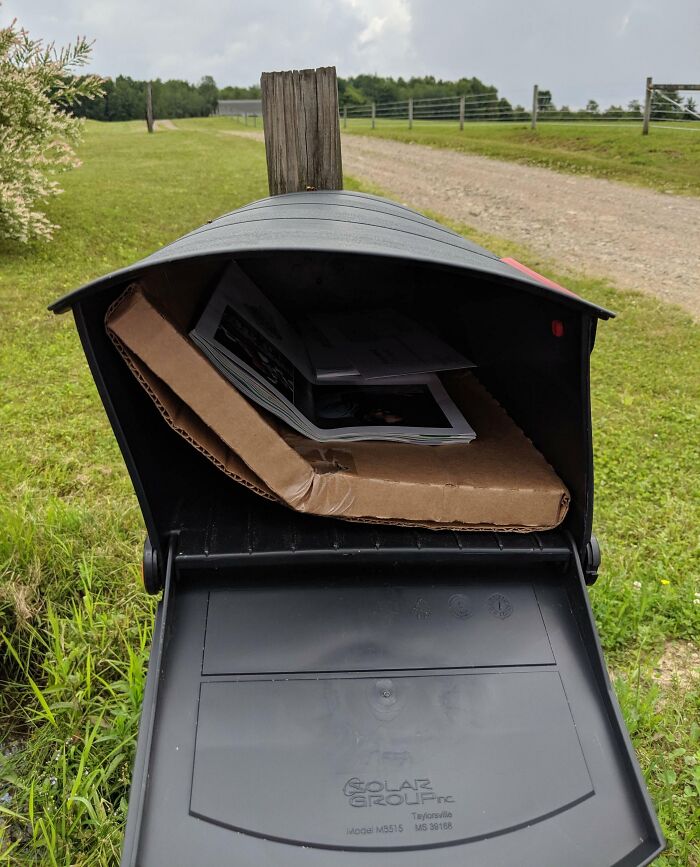 Rural mailbox with a bent package delivered inside, illustrating deliveries that went totally off track.