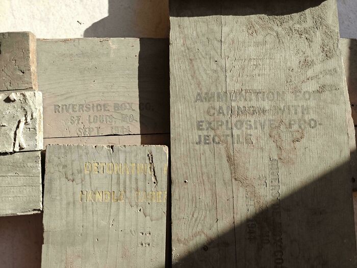 Faded wooden crates with vintage lettering reflecting life and industry in the 1950s captured in a historic photo.