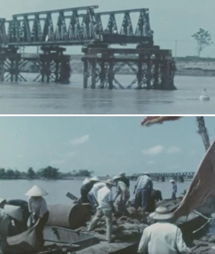 Flooded damaged bridge over river and people in hats working on repairs during a natural disaster recovery effort.