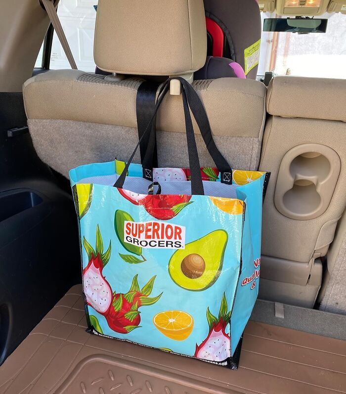 Reusable grocery bag hanging from car seat, illustrating car accessories for passengers using seat as storage unit.