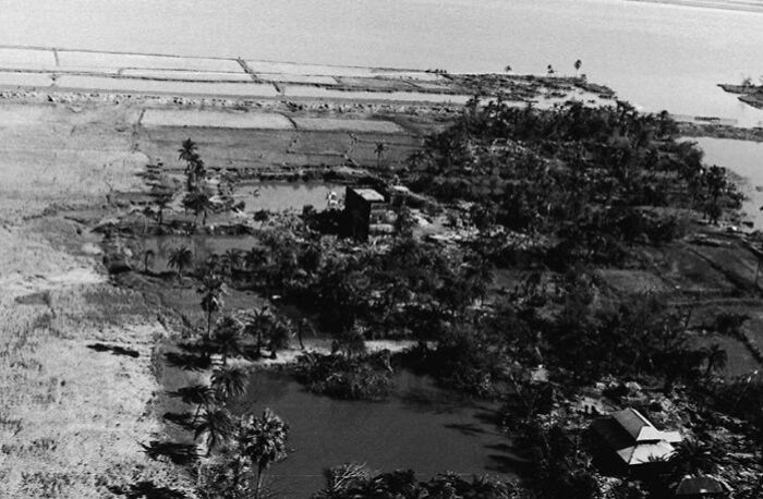 Aerial view of natural disaster damage with flooded land and destroyed vegetation in a large affected area.