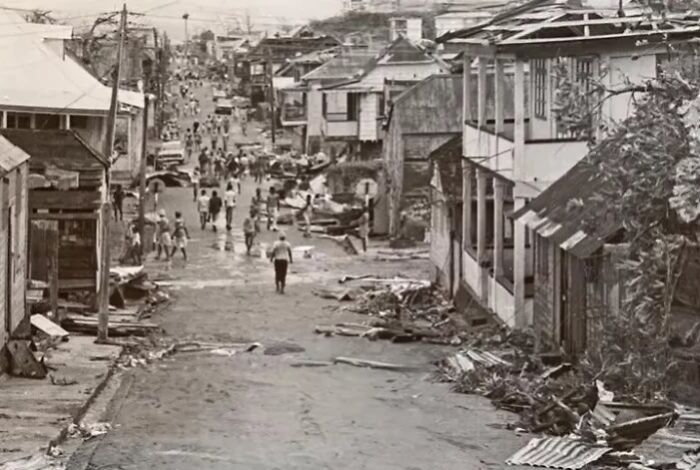 Damaged street with debris and damaged houses after a large natural disaster overwhelming the community's coping ability.