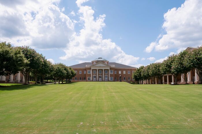 Large historic building with columns surrounded by trees under blue sky, illustrating the best places to live in the USA.
