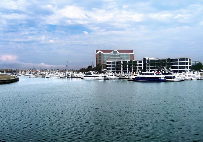 Marina with boats and modern buildings under a partly cloudy sky in one of the best places to live in the USA.