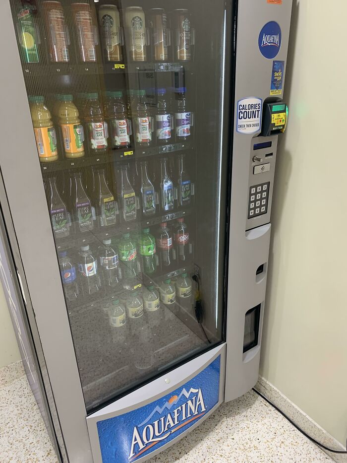 Vending machine stocked with various drinks in a school, illustrating differences in school facilities and resources.