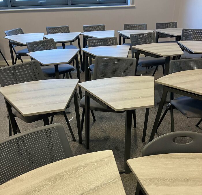Classroom with uniquely shaped desks and chairs highlighting that not all schools are created equal in education spaces.