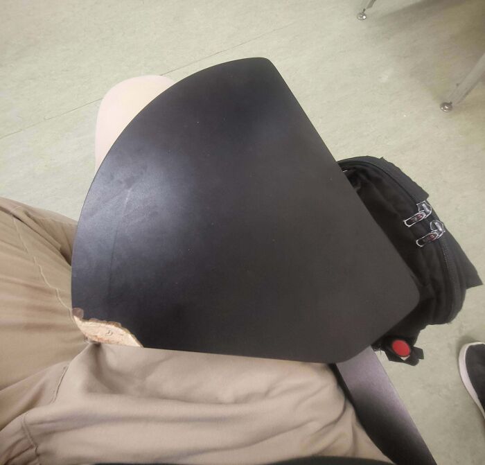 Worn and damaged school desk attached to chair, highlighting the varying conditions of schools and school furniture.