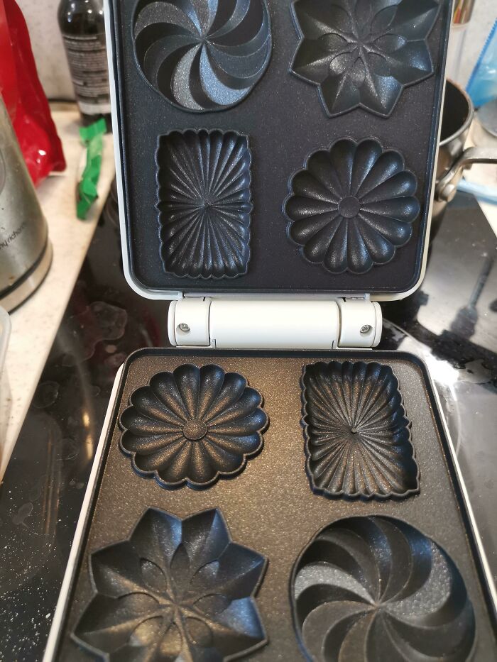 Black mold shapes inside a baking mold with symmetrical patterns, showing a setup that might trigger OCD tendencies.