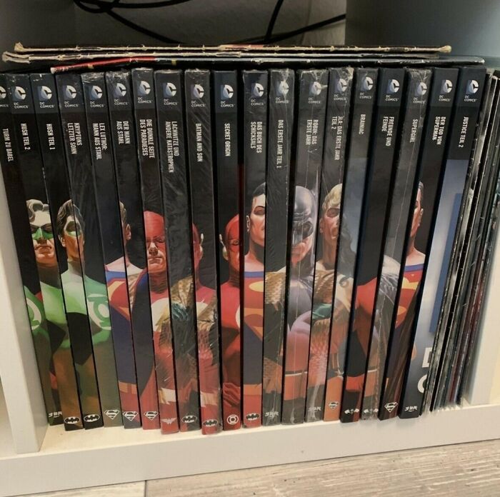 DC Comics graphic novels neatly arranged with superhero spines, a collection likely to annoy people with OCD.