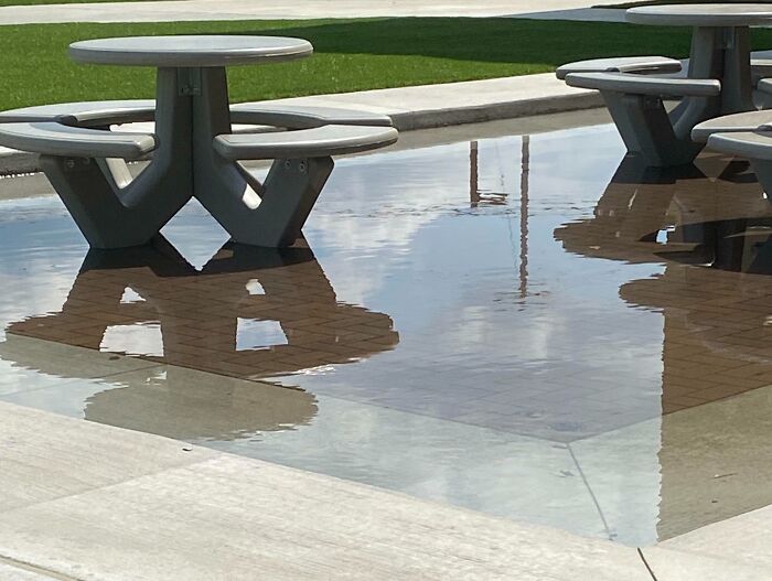 Outdoor school picnic tables partially submerged in water, illustrating problems not all schools are created equal or great