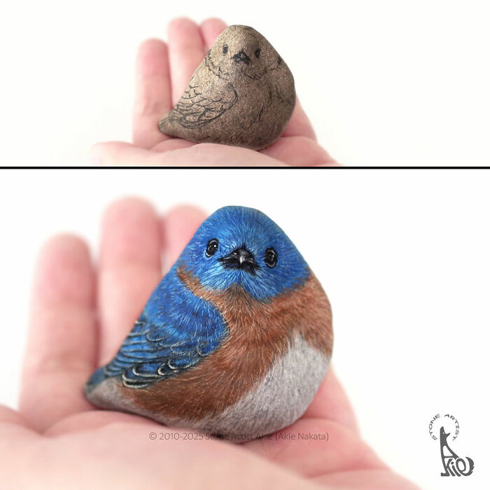 Hand holding a stone transformed by Japanese artist into a realistic, adorable blue and brown bird animal sculpture.
