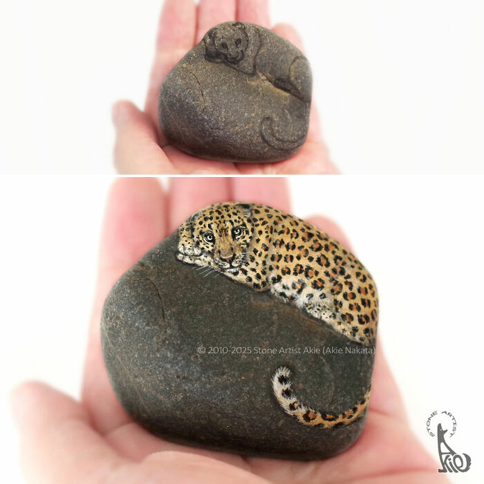 Hand holding stones painted by Japanese artist to resemble adorable animals, including a detailed leopard and a sleeping otter.