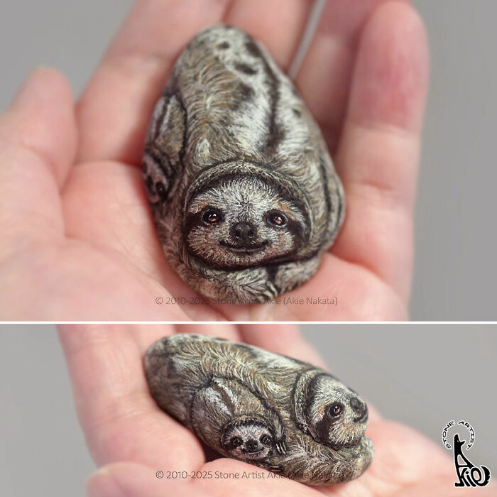 Hand holding stones painted by Japanese artist to look like adorable animals with detailed fur and faces.