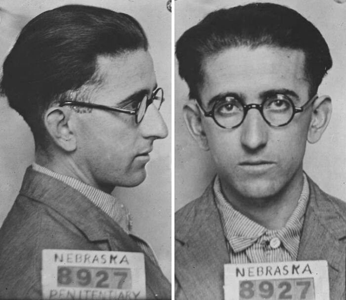Black and white historical mugshot of a man wearing glasses with Nebraska penitentiary identification.