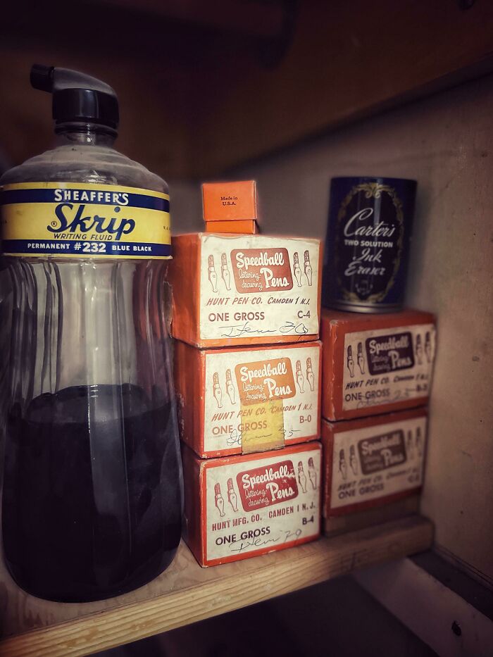 Vintage ink bottles and Speedball pens capturing the essence of life in the 1950s on a wooden shelf.