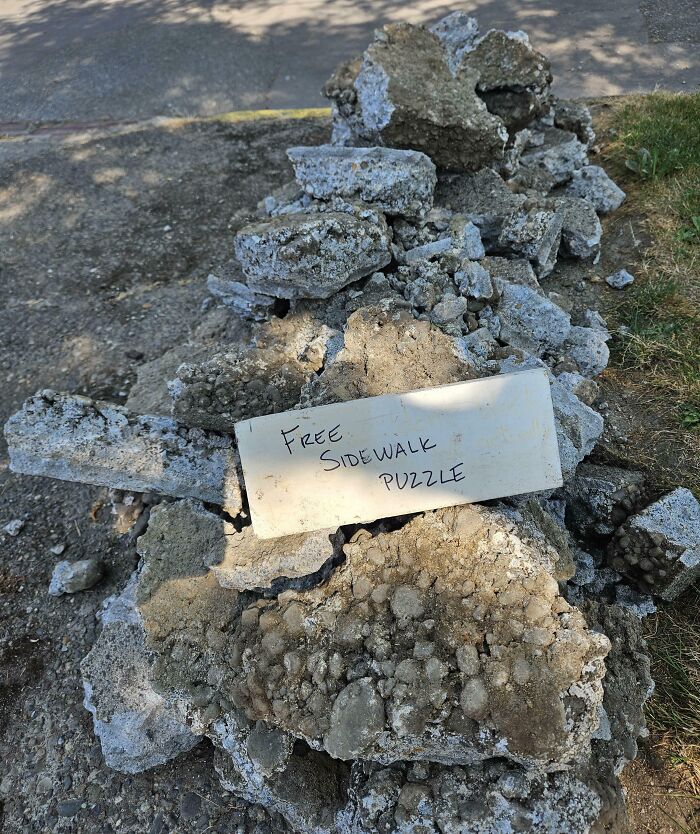 Pile of broken concrete sidewalk pieces with a handwritten sign offering a free sidewalk puzzle, showcasing hilarious dads humor.