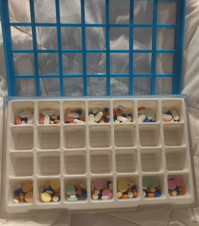 Plastic pill organizer tray filled with various colorful pills, illustrating medical photos and medication management.