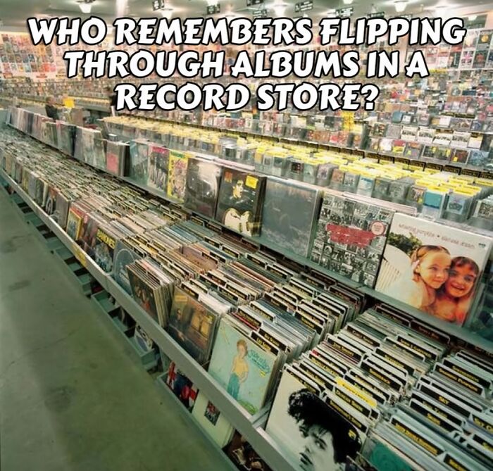 Rows of vinyl records in a record store, evoking nostalgia for anyone who grew up in the 80s flipping through albums.