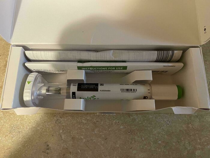 Medical photos showing a close-up of a syringe device in packaging with instructions for use on a countertop surface.