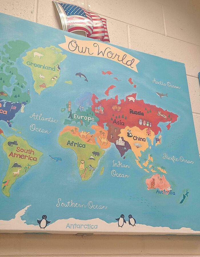 Colorful world map mural in a school classroom showing continents and oceans, highlighting school environment differences.
