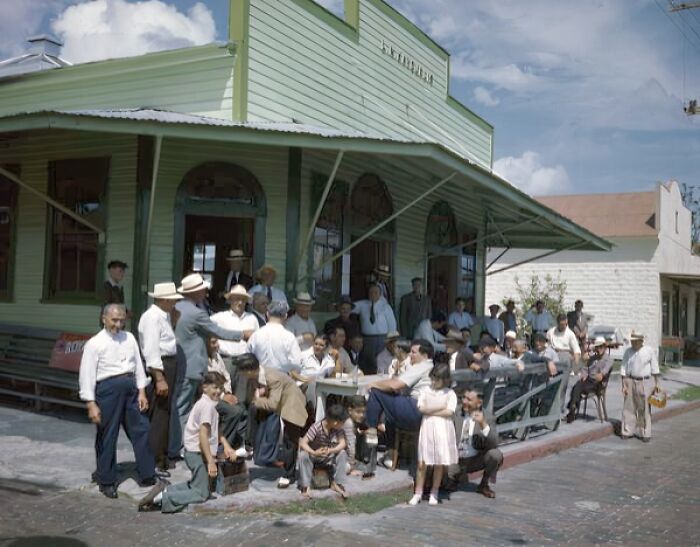 Group of people gathered outside a vintage building, showcasing everyday life in 1950s Florida.