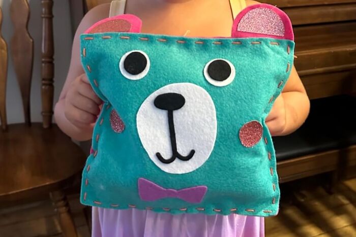 Child holding a colorful bear-themed plush toy, one of the 20 toys under 20 dollars perfect for gifting.