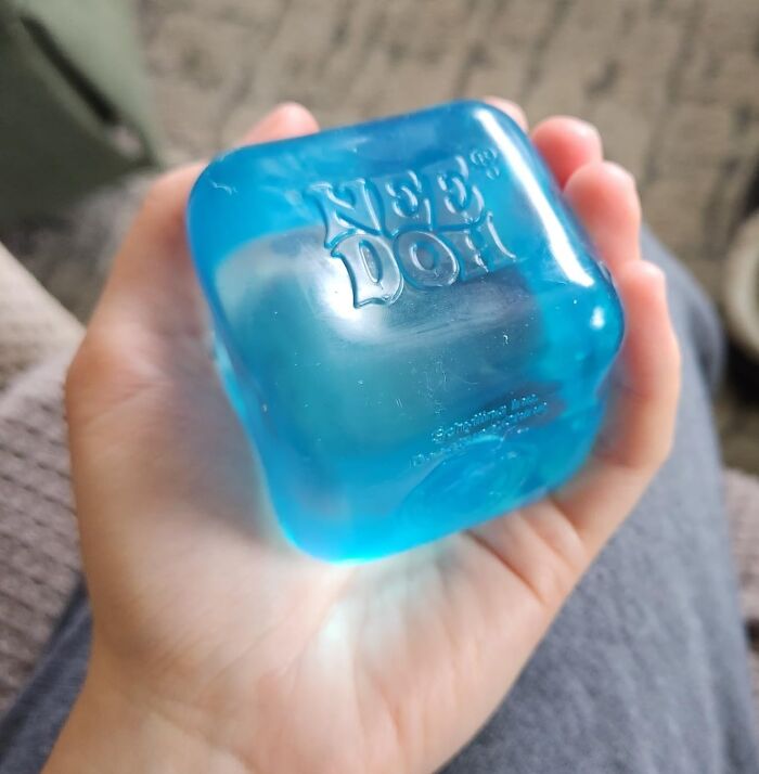 Hand holding a blue Nee Doh stress relief toy, one of the top toys under $20 for gifting genius ideas.