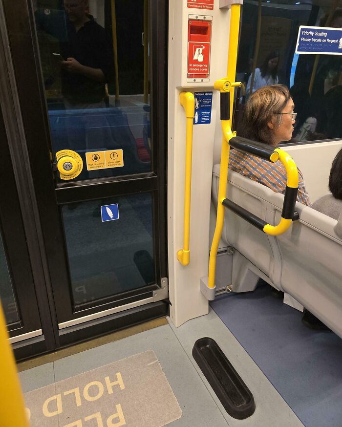 Bus interior with yellow handrails and priority seating, showcasing a genius solution for common public transit problems.