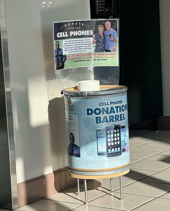 Cell phone donation barrel placed indoors encouraging donations to solve overlooked problems with free 911 phones.