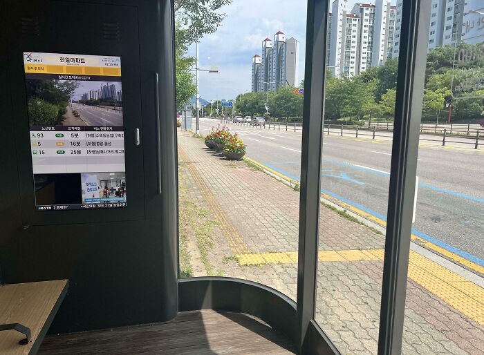 Modern bus stop with digital display showing real-time transit info, offering a genius solution to overlooked commuter problems.