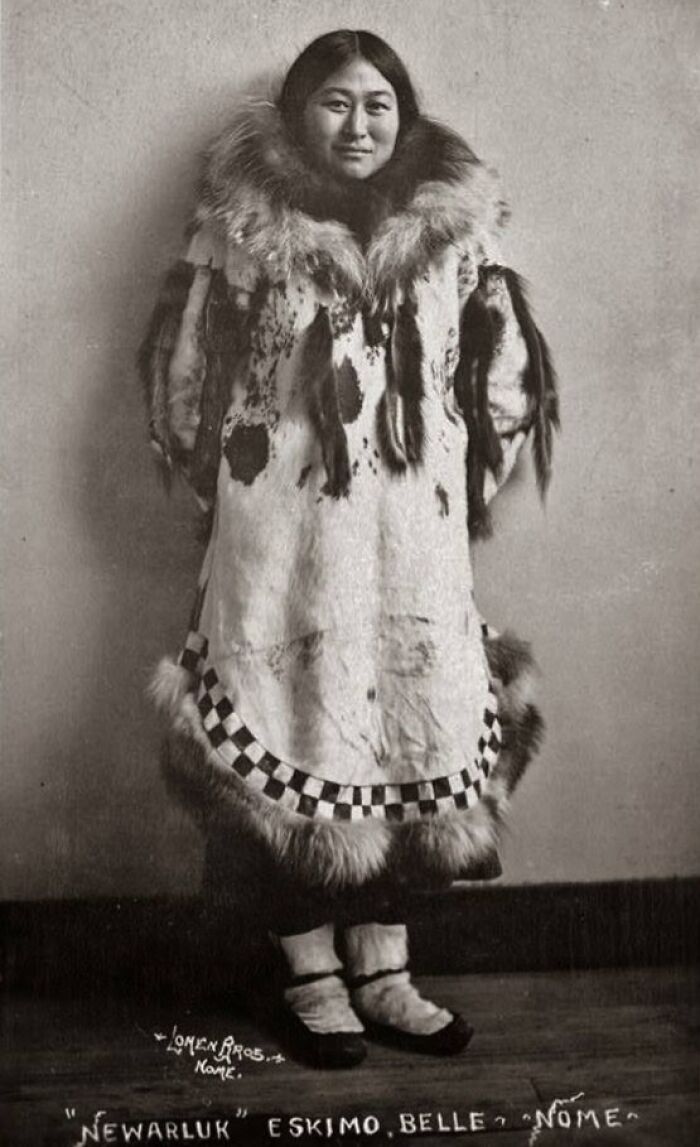 Historic black and white photo of an Inuit woman wearing traditional fur clothing, showcasing Inuit culture and resilience.