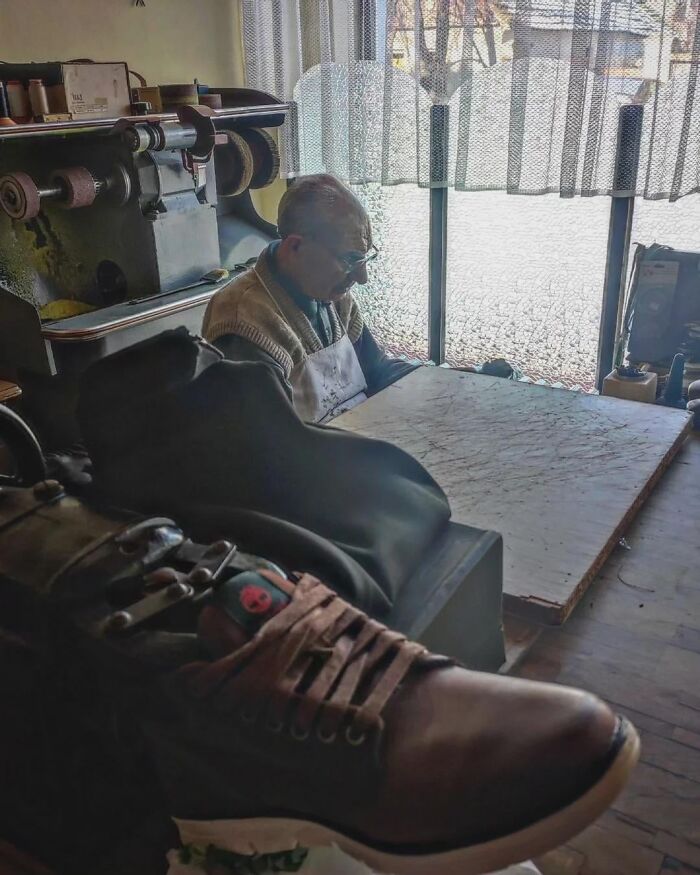 Elderly man working with leather shoes in a rustic workshop, showcasing craftsmanship and the beauty of planet Earth.
