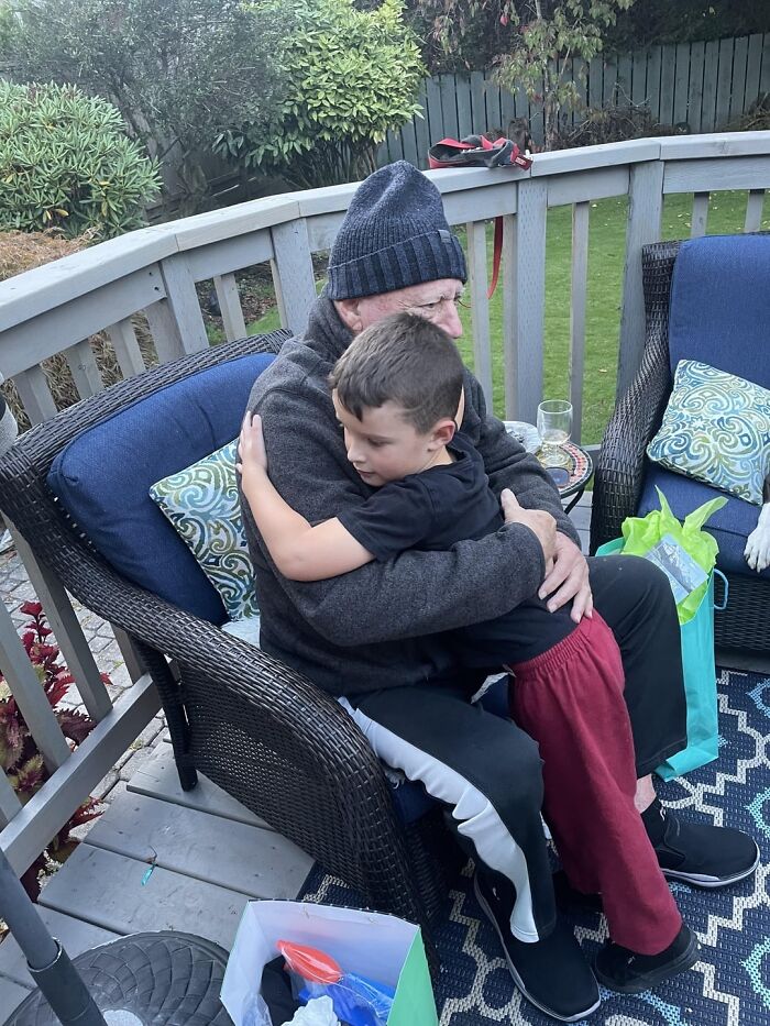 Elderly man and young boy sharing a warm hug outdoors, celebrating the beauty of planet Earth and family connection.