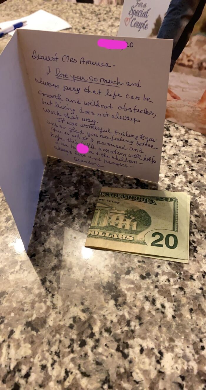 Handwritten card expressing love and prayers with a twenty-dollar bill on a granite countertop, showing beauty of planet Earth.