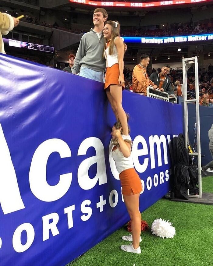 Cheerleaders helping a fan at a sports event showcasing the beauty of Planet Earth through community spirit.